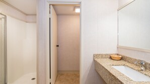 A bathroom with a granite countertop, a wooden bowl sink, and a mirror above the sink. - Mountainside Inn 309 1 Bedroom Hotel Room by Alpine Lodging Telluride (Telluride)