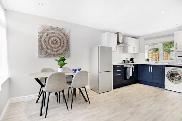Enjoy meals in the kitchen with oven, refrigerator, and washing machine, and dine at the table with four chairs.
