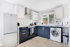 Enjoy cooking in this well-equipped kitchen with a washing machine, microwave, and refrigerator.