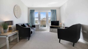 A modern living room with a sofa, two armchairs, a TV, and a dining table. - Duplex apartment, close to A1, private car park (Darlington)