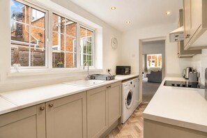 A modern kitchen with a large window, built-in appliances, and a view of the outside.