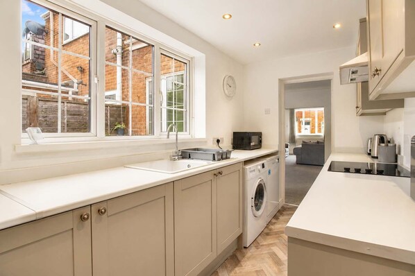 A modern kitchen with a large window, built-in appliances, and a view of the outside.