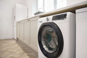 Een voorlader wasmachine in een wasserij met een visgraatvloer.