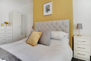 A bedroom with a bed, a bedside table, a lamp, a wardrobe, and a framed picture on the wall. - Peaceful two Bedroom Family Home with Backyard Parking WiFi (Northumberland)