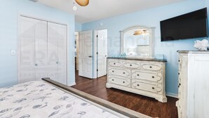 A bedroom with a bed, dresser, TV, and a ceiling fan. - 2706 W. 3rd St 2 Bedroom Home by RedAwning (Fernandina Beach)