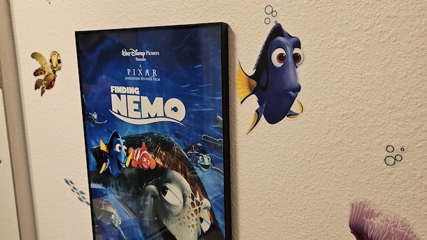 Eine Wand mit einem 'Finding Nemo'-Poster und dekorativen Meerestier-Aufklebern.
