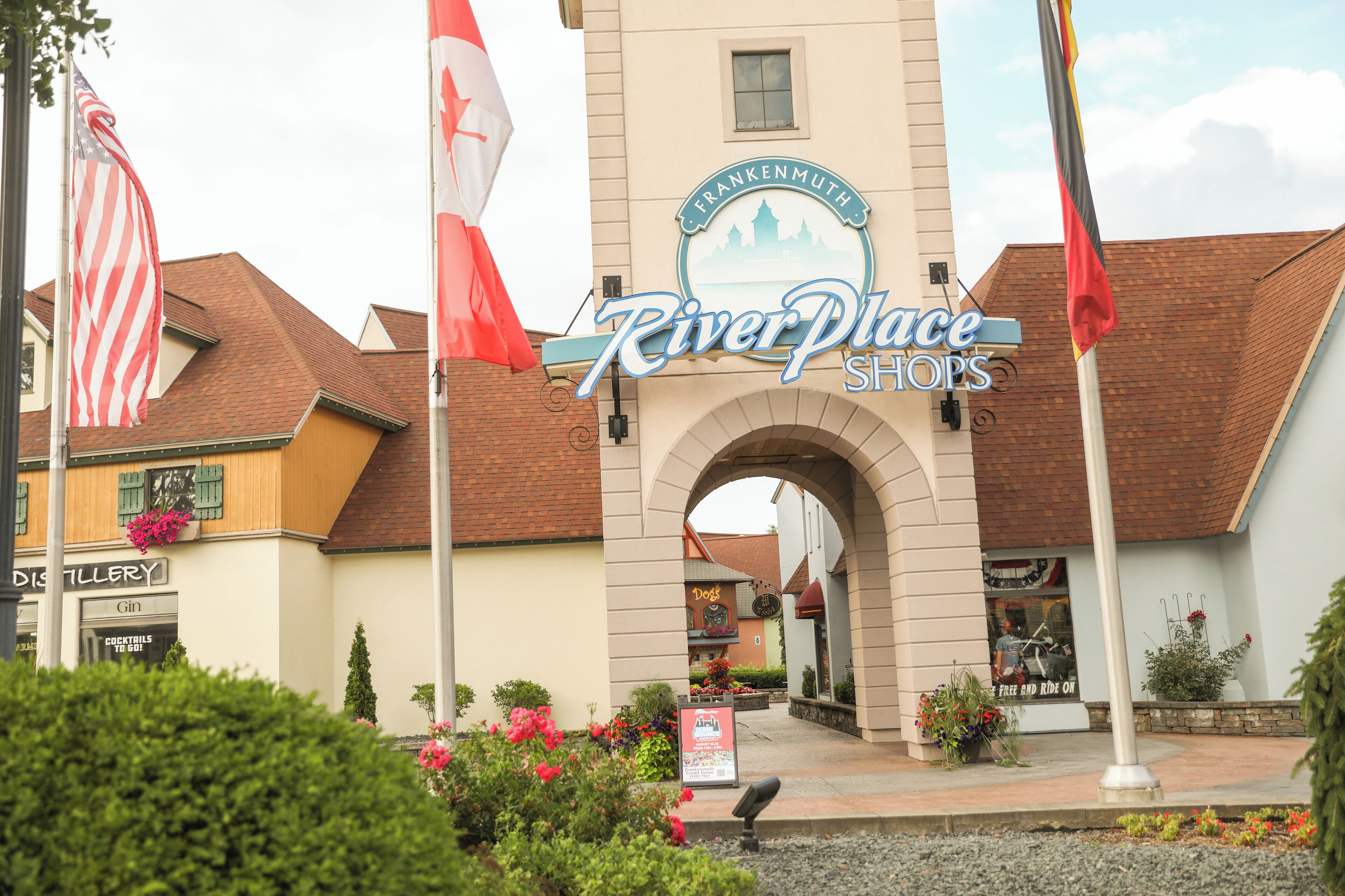 Un edificio con un cartel que dice "River Place Shops" y un cartel anunciando "Frankenmuth Distillery".