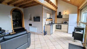 Ein kompakter Wohnraum mit einer Küche, einem Sofa, einem Fernseher und einem Essbereich.