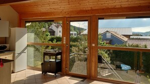 Ein geräumiger Balkon mit Blick auf umliegende Häuser und Grünflächen.