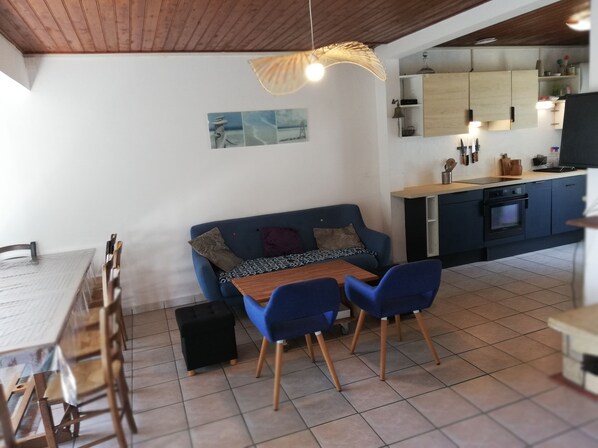 Une cuisine moderne avec un coin repas, un canapé et une table avec des chaises.