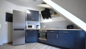 Une cuisine moderne avec des meubles gris, un four à micro-ondes encastré et un four traditionnel.