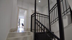 A staircase with black railings leading to an upper floor. - Capuchinos Cathedral (Málaga)