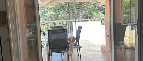 A room with a sliding glass door leading to an outdoor patio area with a table and chairs.