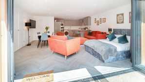 Um interior moderno com cama, sofá, área de refeições e cozinha.