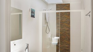 A modern bathroom with a skylight, a glass shower enclosure, and a white sink. - Gracies Cottage - UK44686 (Beamish)