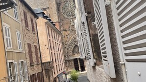 A narrow street with historic buildings, including a church with a large circular window and a stone facade. - T2 Rénové Hyper Centre, à 50 m de la Cathédrale (Rodez)