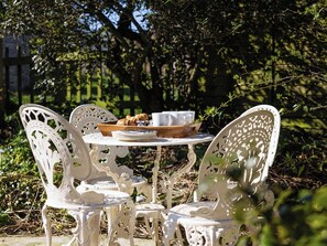 A white metal table with a tray of food and cups, surrounded by ornate white chairs in an outdoor setting. - 2 bedroom accommodation in Ireby, near Bassenthwaite (Ireby, near Bassenthwaite)