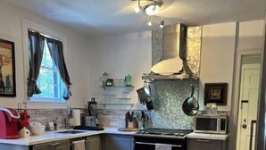 A modern kitchen with a central island, stainless steel appliances, and a window with curtains. - 4-room apartment in quiet, safe neighborhood (Nashville)