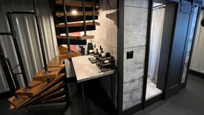 A modern interior with a staircase, a table with bottles, and a door. - Loft Where City Meets Country (Southgate)