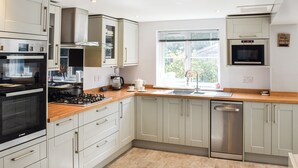 Una cocina moderna con horno integrado, microondas y lavavajillas de acero inoxidable.