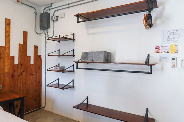 Una habitación con varias estanterías de madera, una cama y un separador de madera.