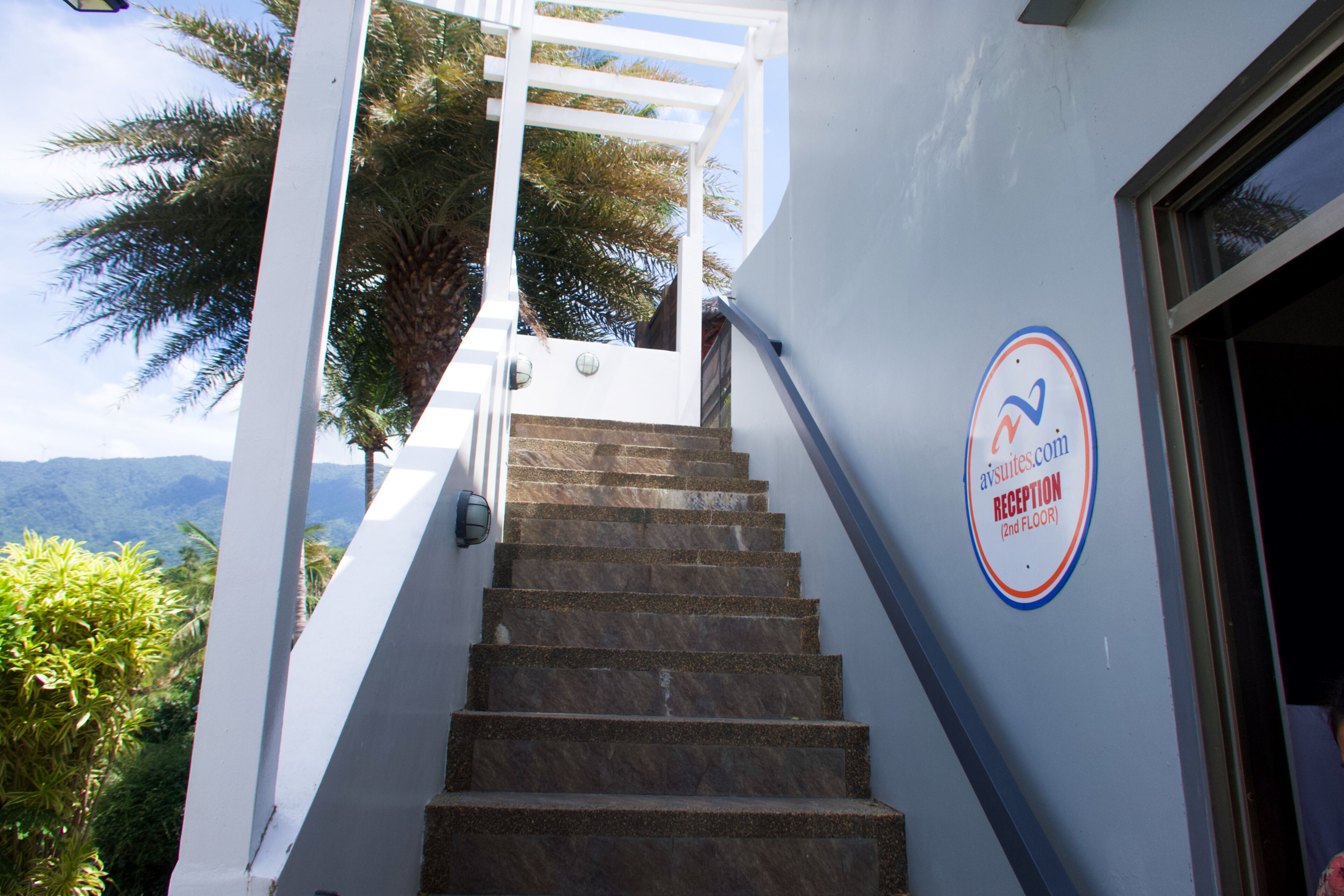 A staircase leading to a reception area with a sign indicating the location.