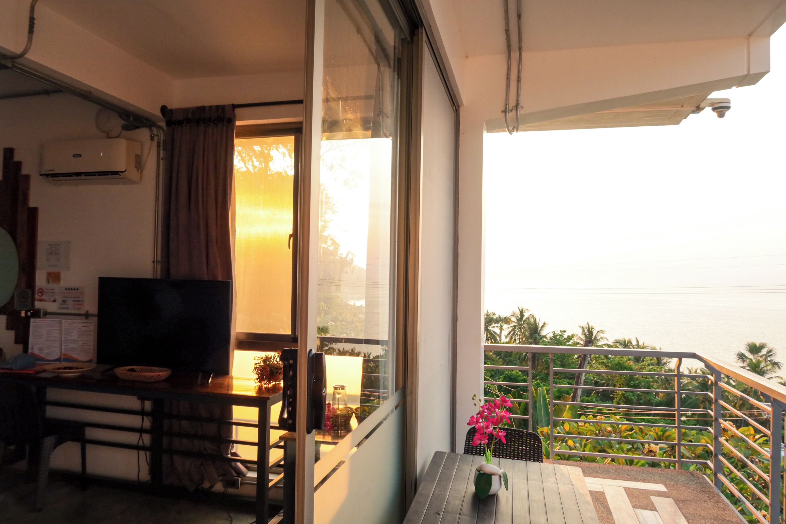 Un balcon équipé d’une télévision, d’une table et d’une chaise.