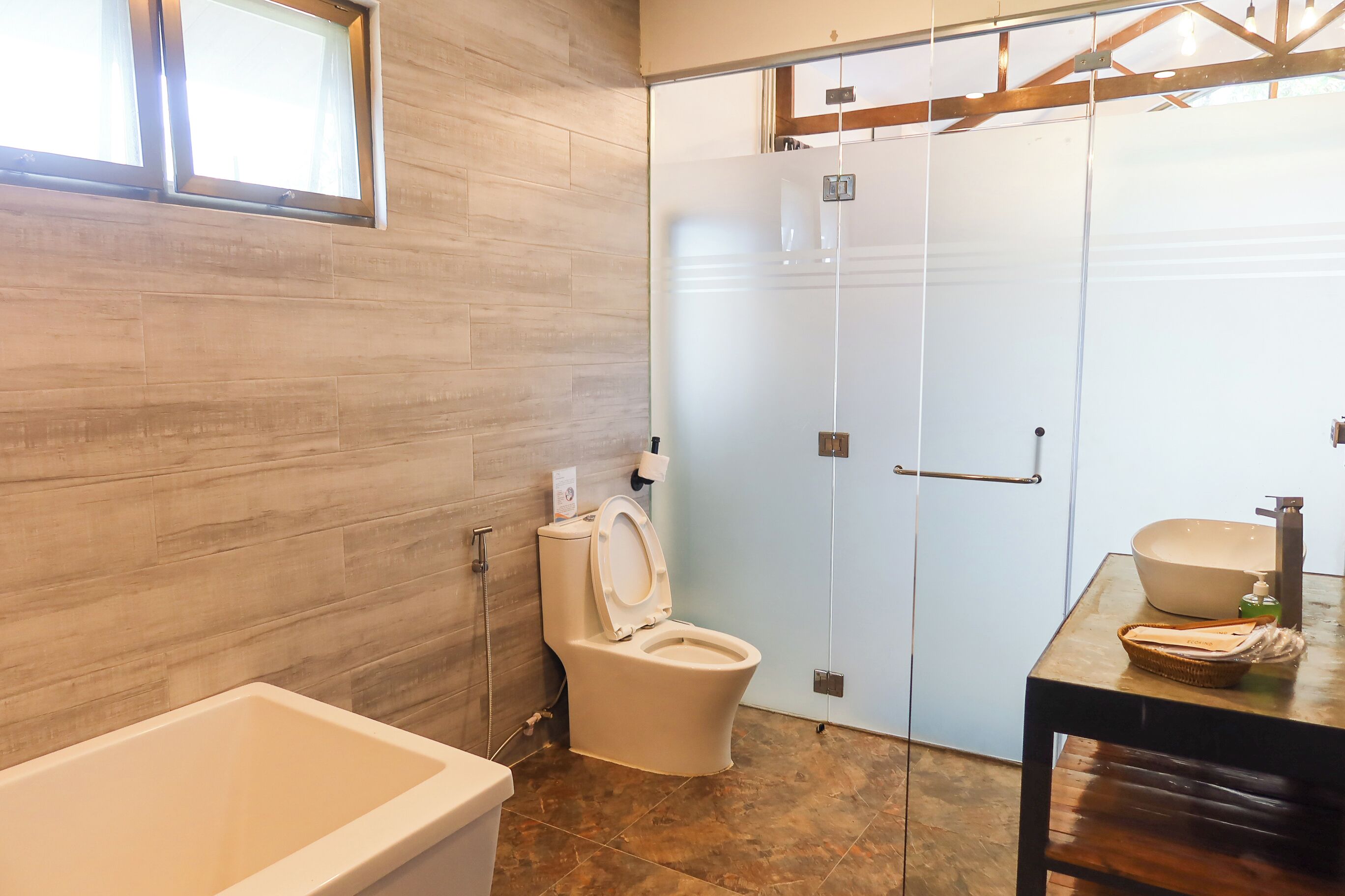 A modern bathroom with a bathtub, toilet, and sink.