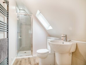 Une salle de bain moderne avec une douche à parois de verre, des toilettes blanches et un lavabo avec un robinet.