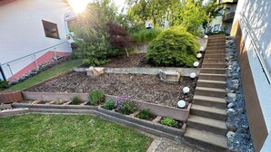 Um jardim ajardinado com um caminho de pedra que leva a um conjunto de degraus.