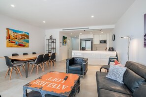 A modern living room with a dining area, a kitchen in the background, and a painting on the wall. - AM-7 Modern house with shared pool (Llafranc)