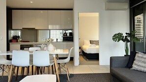 A modern apartment with a dining area, kitchen, and living room. - Incredible 2 BR City Apartment (Melbourne)