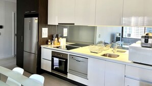 A modern kitchen with stainless steel appliances, a built-in oven, and a dishwasher.