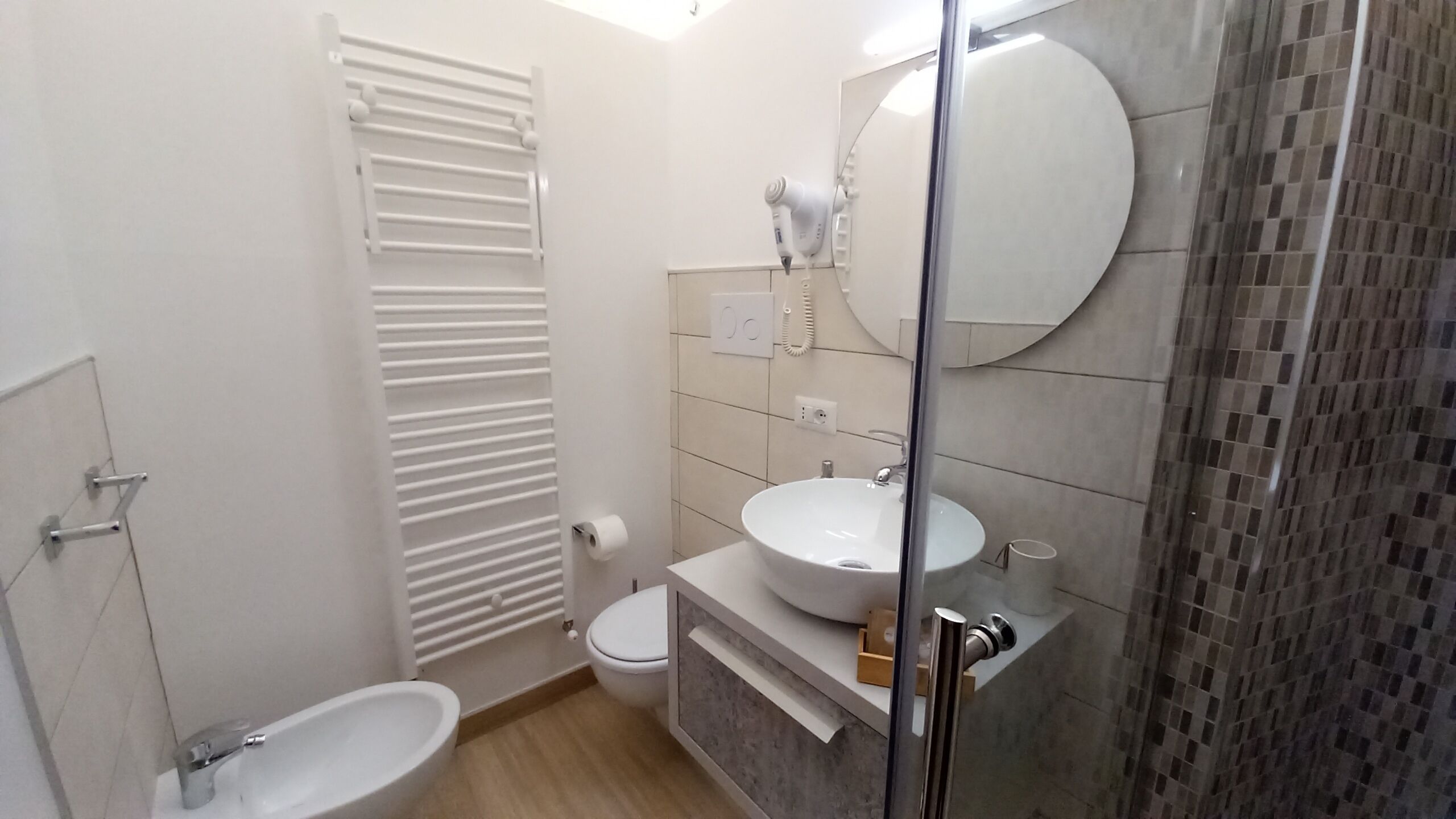 A modern bathroom with a toilet, bidet, and sink.
