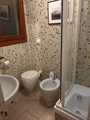 A bathroom with a toilet, bidet, and bathtub.
