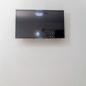 A flat-screen TV mounted on a wall. - Hotel Las Palmas en Laurel (Cancun)