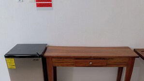 Une petite cuisine équipée d’un réfrigérateur et d’une petite table en bois.