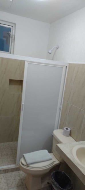 Un baño con inodoro, ducha y lavabo.