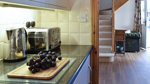 A kitchen with a toaster, kettle, and a cutting board with grapes. There is a staircase leading to another room. - 2 bedroom accommodation in Thirkleby, near Thirsk (Thirkleby, near Thirsk)