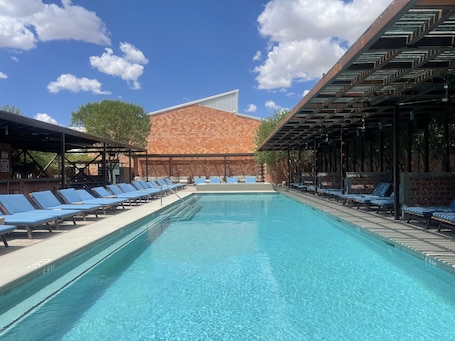 Una piscina al aire libre de temporada, sillones reclinables de piscina