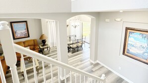 A multi-level interior with a staircase, a dining area, and a living room. - High Grove Hideaway, Spacious 5BR Villa w/ Pool Near Disney (Four Corners)