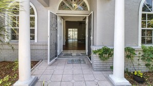 A house entrance with a welcome mat, a door, and a staircase leading inside.