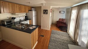 A compact kitchen with wooden cabinets, a built-in oven, and a refrigerator.