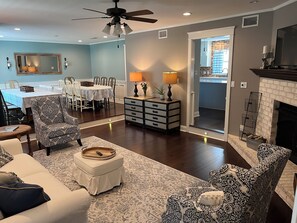 Cozy living room with a comfortable seating area, dining table, and fireplace.