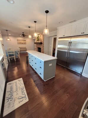 Enjoy cooking in this kitchen with a central island, ample storage, and a brick fireplace.