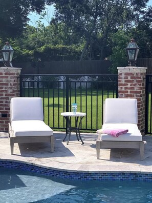 Relax by the pool with comfortable lounge chairs and a refreshing drink.