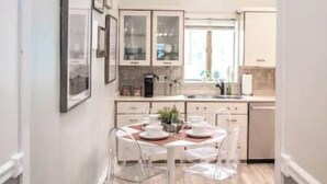 Eine moderne Küche mit Dachfenster, Deckenventilator und einem Essbereich mit transparenten Stühlen und einem runden Tisch.
