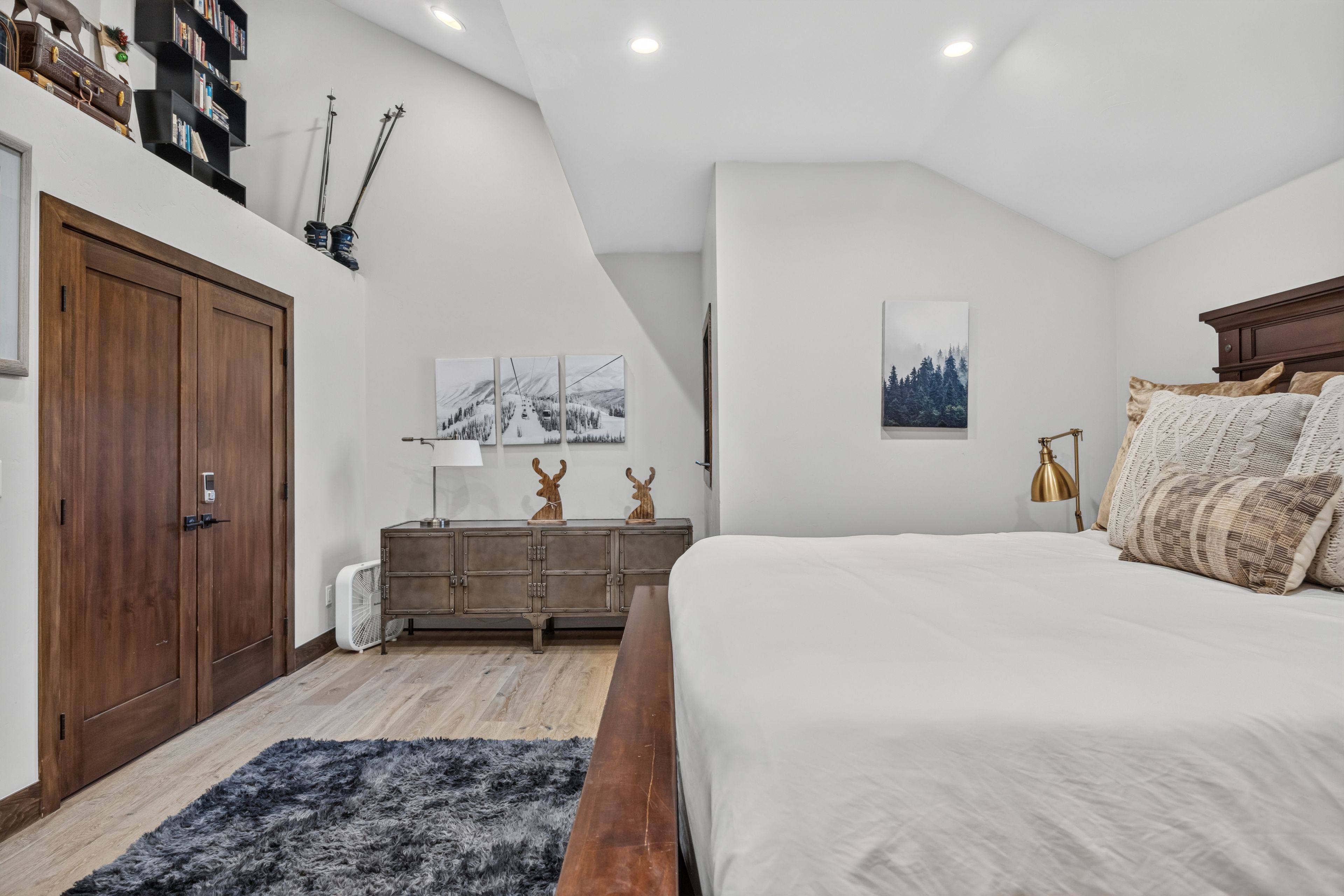 Un dormitorio con una cama grande, un armario, un tocador y un ventilador de techo.