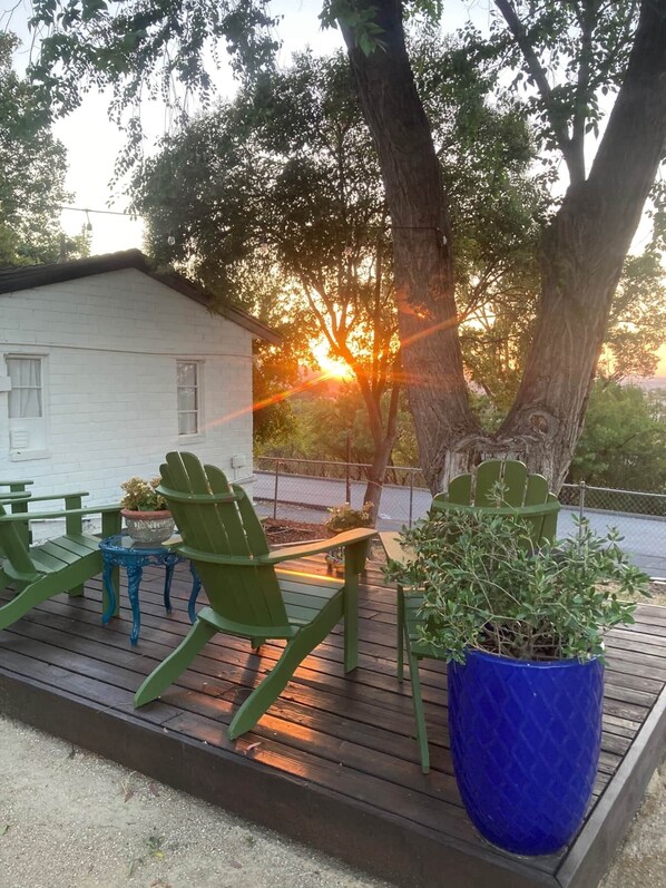 A deck with green Adirondack chairs, a blue table, and a potted plant. - Hilltop Paso: Dog Friendly, Firepit, BBQ, Views (Paso Robles)