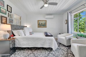 A bedroom with a bed, a nightstand, a chair, a window with a view, and a ceiling fan. - Hilltop Paso: Dog Friendly, Firepit, BBQ, Views (Paso Robles)